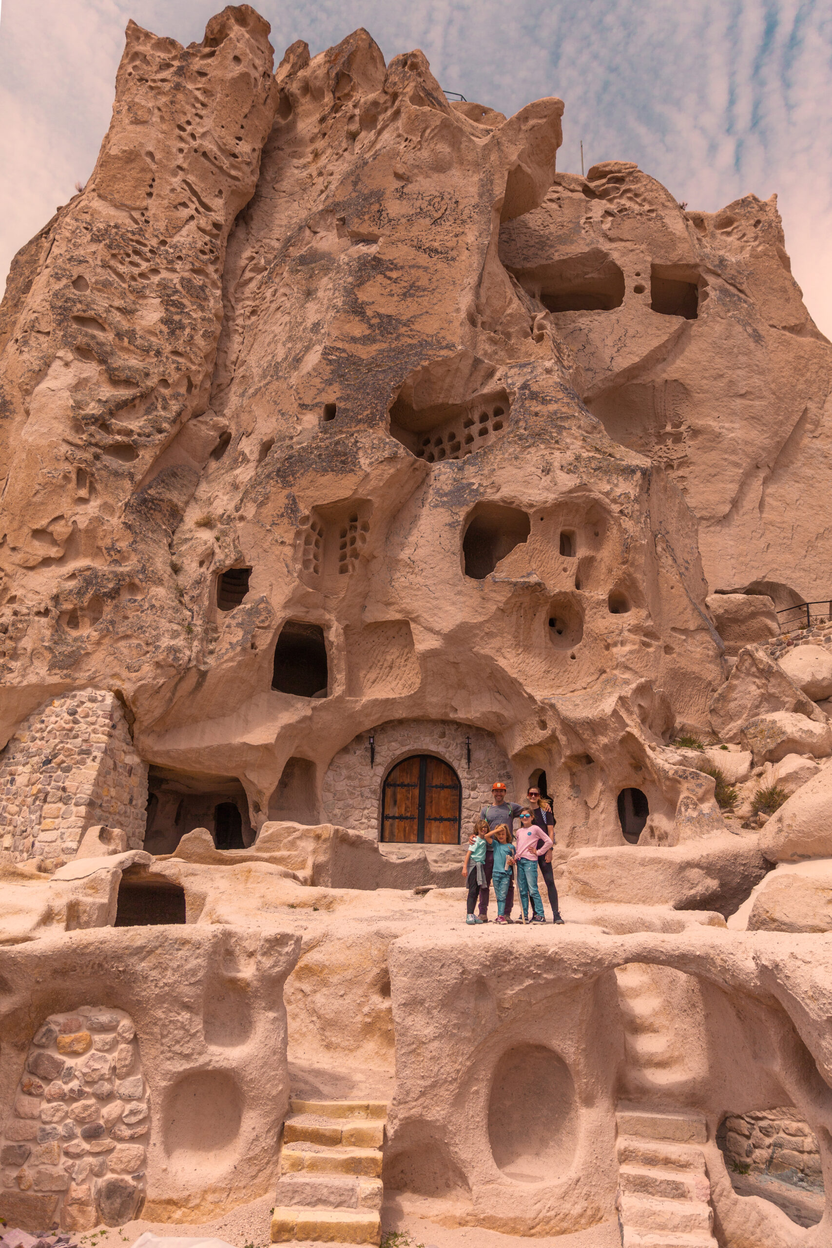 family in front of cave homes