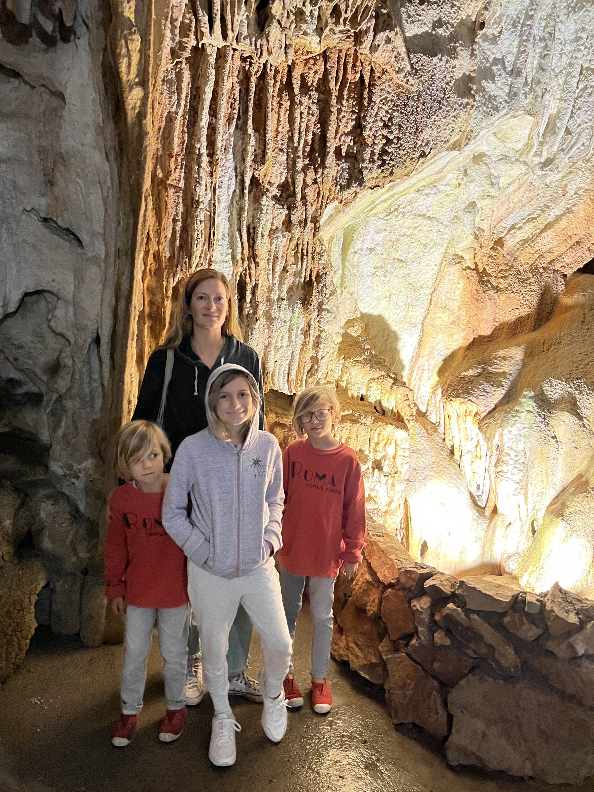 a woman and two children posing in a cave