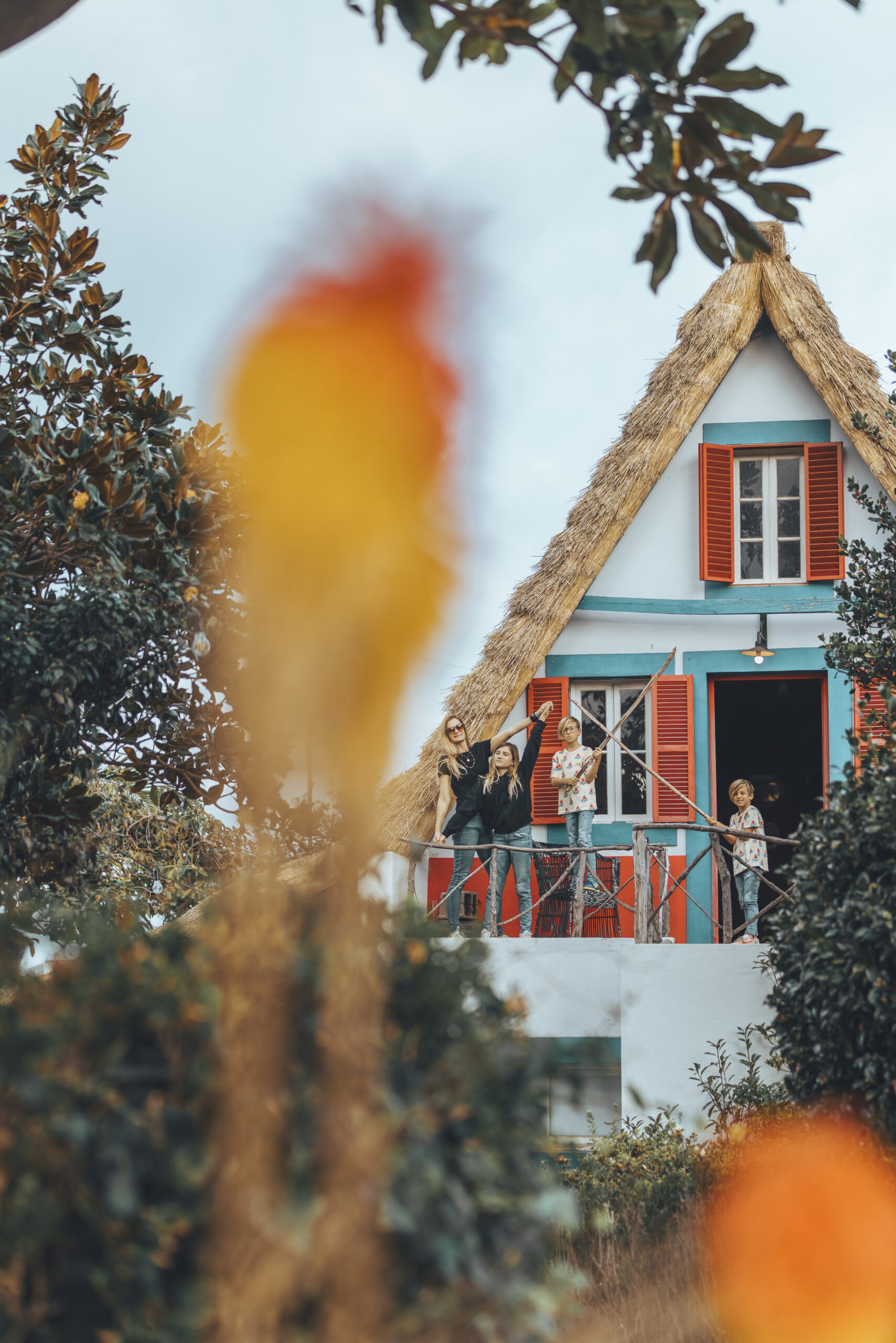 a group of people standing on a balcony in front of a house