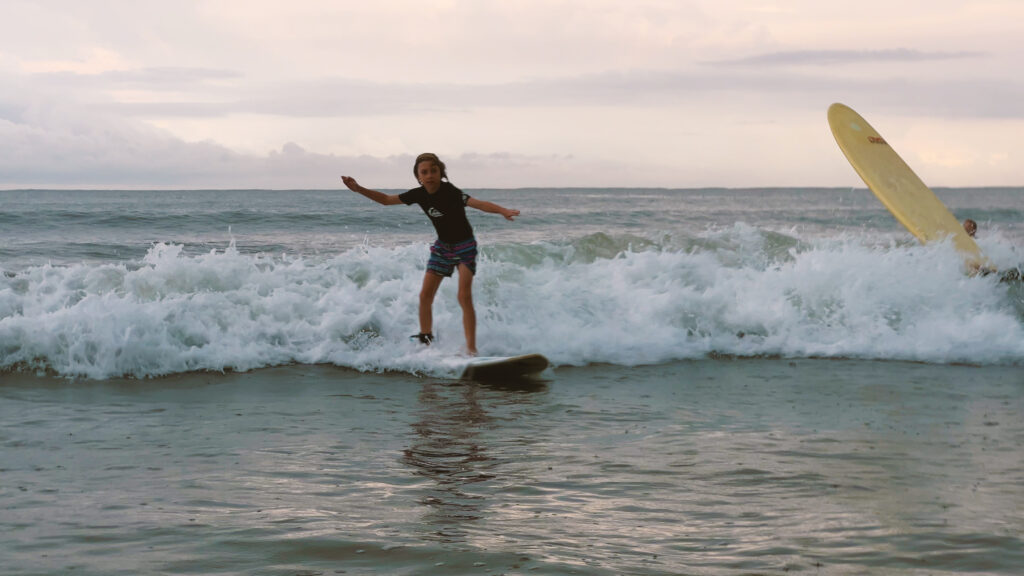 Child surfing in ocean waves.