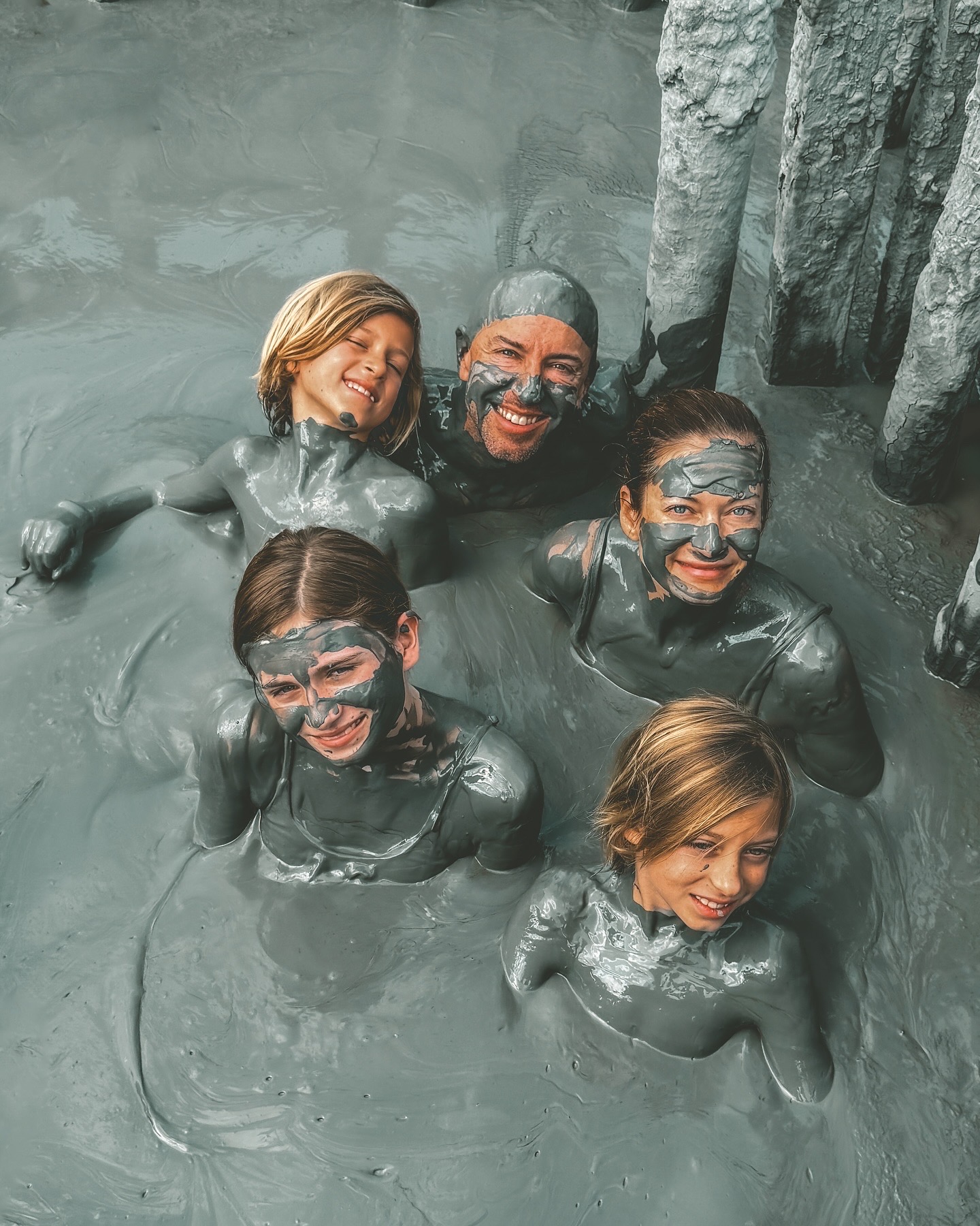 Family in grey mud bath